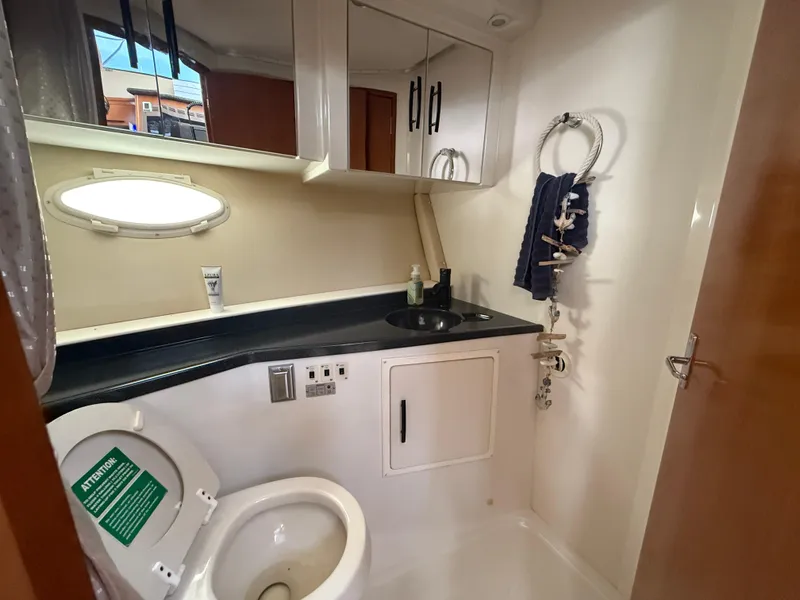 Slide: The Image of 2005 Carver 41 Cockpit Motor Yacht bathroom with sink, toilet, and storage cabinets. - 10