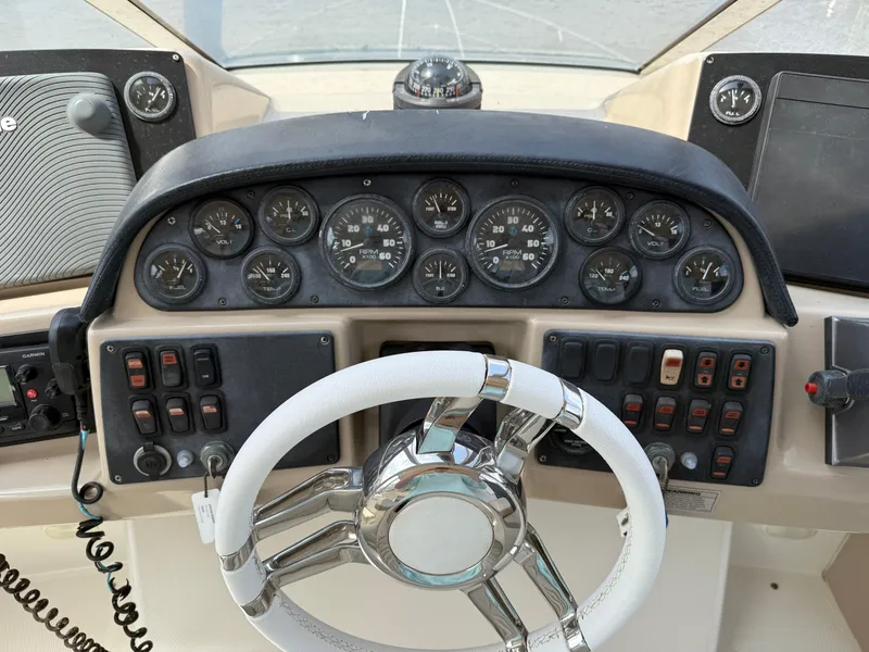 Slide: The Image of 2005 Carver 41 Cockpit Motor Yacht dashboard with steering wheel and control panel. - 12