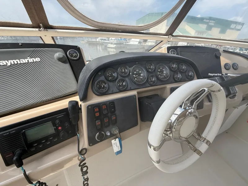 Slide: The Image of 2005 Carver 41 Cockpit Motor Yacht helm with Raymarine electronics and white steering wheel. - 14