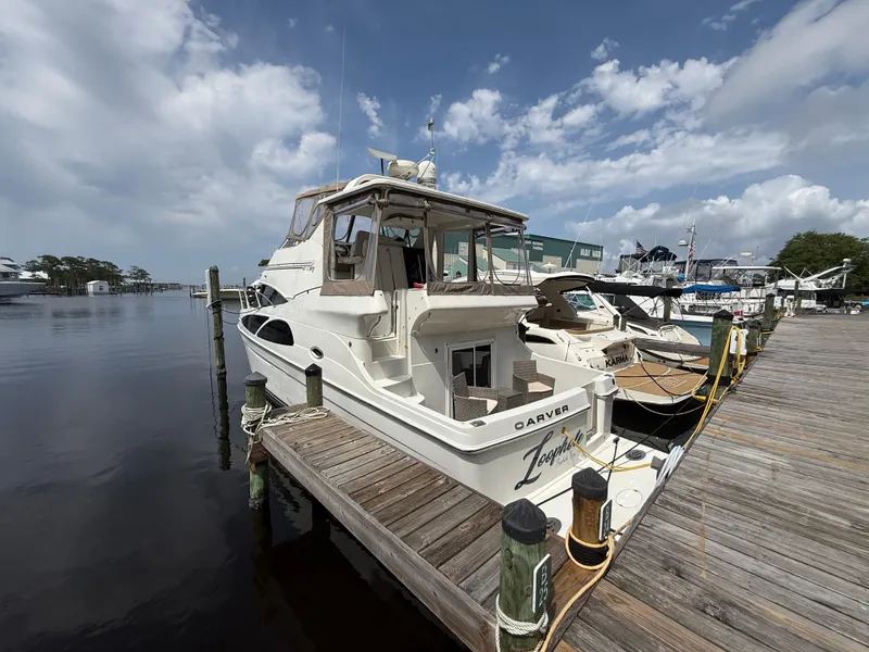 Slide: The Image of 2005 Carver 41 Cockpit Motor Yacht docked at marina under cloudy sky. - 3