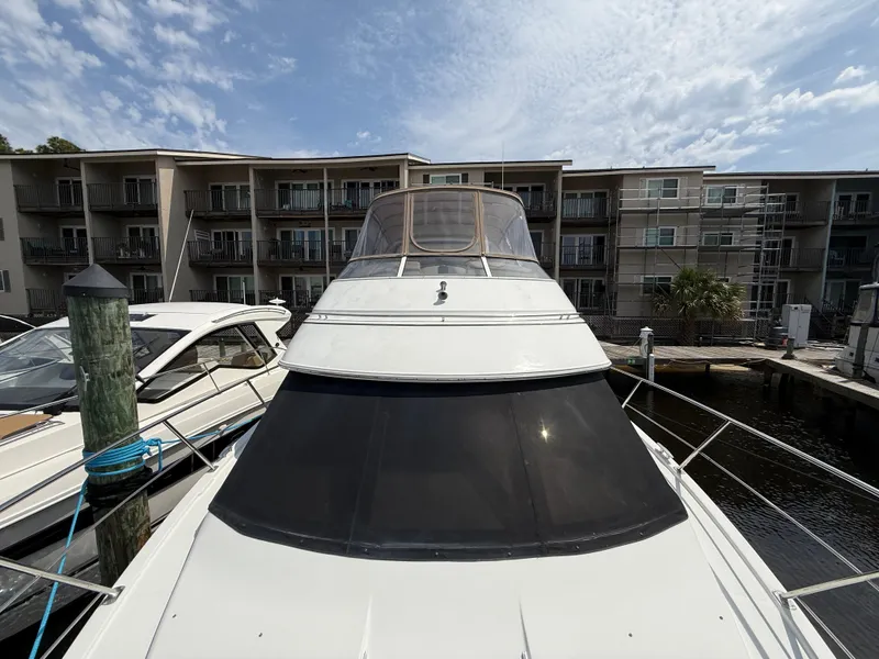 Slide: The Image of 2005 Carver 41 Cockpit Motor Yacht docked near waterfront apartments. - 5