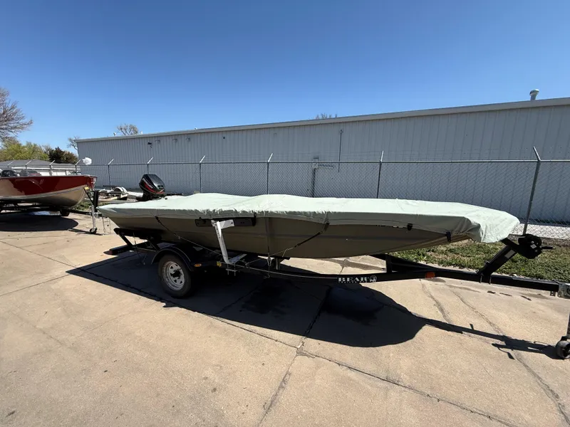 Slide: The Image of 2002 Tracker Grizzly 1648 boat on trailer, covered, parked outdoors. - 2