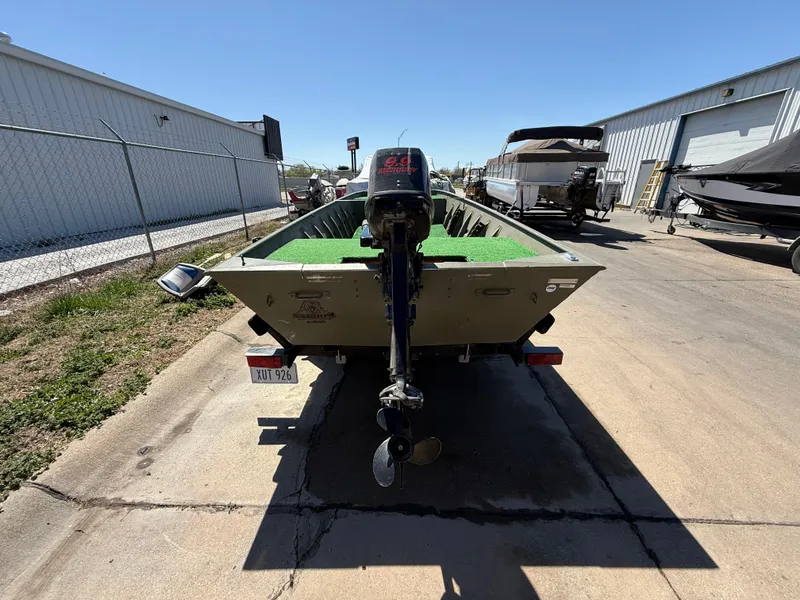 Slide: The Image of 2002 Tracker Grizzly 1648 boat with outboard motor, parked outdoors on concrete. - 3