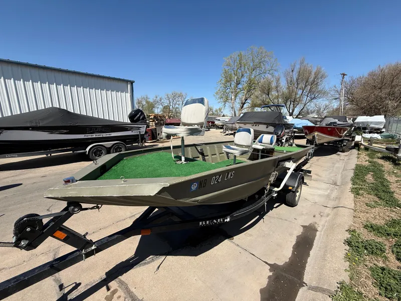 Slide: The Image of 2002 Tracker Grizzly 1648 boat on trailer, parked outdoors under clear blue sky. - 7