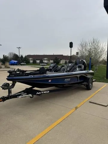 Slide: The Image of 2021 Tracker Nitro Z19 boat parked on a concrete surface, overcast sky. - 3