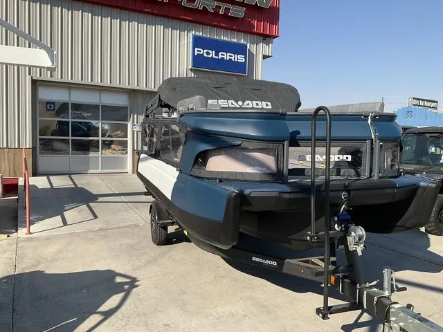 Slide: The Image of 2024 Sea-Doo Switch® Cruise 21 - 230 hp boat on trailer outside Polaris dealership. - 3