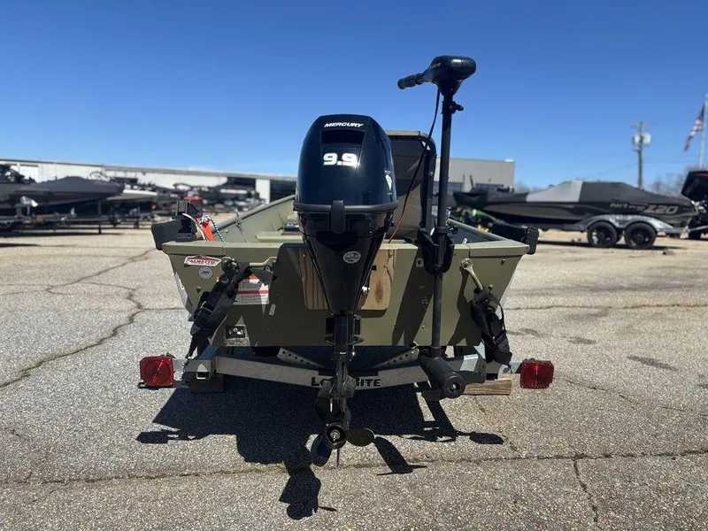 Slide: The Image of 2024 Lowe L1240 Jon boat with Mercury 9.9 motor on trailer, outdoor setting. - 3