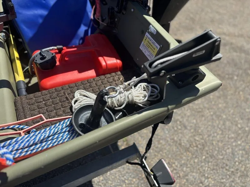 Slide: The Image of 2024 Lowe L1240 Jon boat with ropes, fuel tank, and accessories on deck. - 8