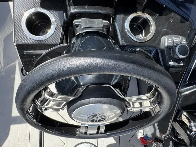 Slide: The Image of Steering wheel of 2021 Yamaha Boats 255XD with control panel and cup holders. - 16