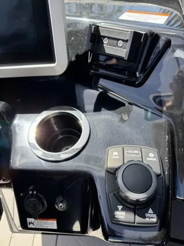 Slide: The Image of Control panel of a 2021 Yamaha Boats 255XD, featuring a cup holder and navigation controls. - 17