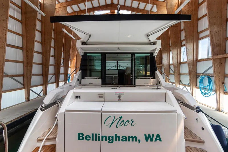 Slide: The Image of 2023 Tiara Yachts C44 Coupe docked in a wooden boathouse, named "Noor" from Bellingham, WA. - 12