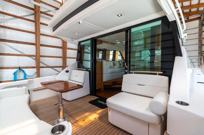 Slide: The Image of 2023 Tiara Yachts C44 Coupe interior with elegant seating and wooden accents. - 13