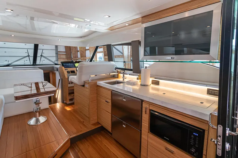 Slide: The Image of Interior of 2023 Tiara Yachts C44 Coupe, featuring modern kitchen and seating area. - 20