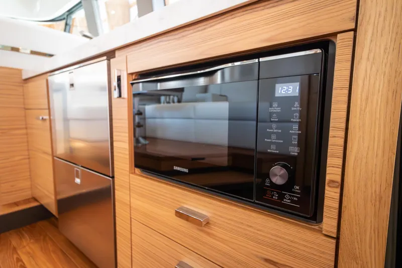 Slide: The Image of 2023 Tiara Yachts C44 Coupe kitchen with modern appliances and wood cabinetry. - 23