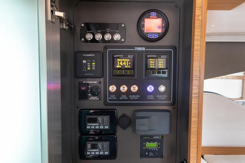 Slide: The Image of 2023 Tiara Yachts C44 Coupe control panel with digital displays and switches. - 27