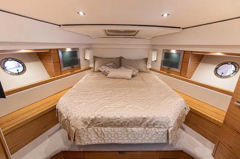 Slide: The Image of Luxurious bedroom interior of 2023 Tiara Yachts C44 Coupe with elegant bedding and wood accents. - 29