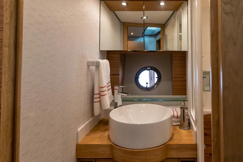 Slide: The Image of Luxurious bathroom in 2023 Tiara Yachts C44 Coupe with modern fixtures and porthole window. - 32