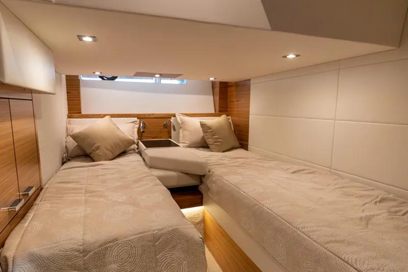 Slide: The Image of 2023 Tiara Yachts C44 Coupe cabin with twin beds and modern lighting. - 33