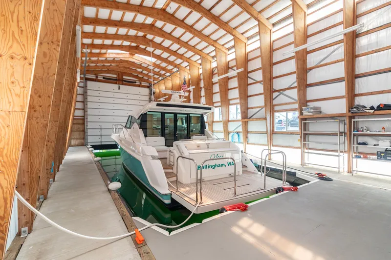Slide: The Image of 2023 Tiara Yachts C44 Coupe docked in a spacious indoor marina. - 5
