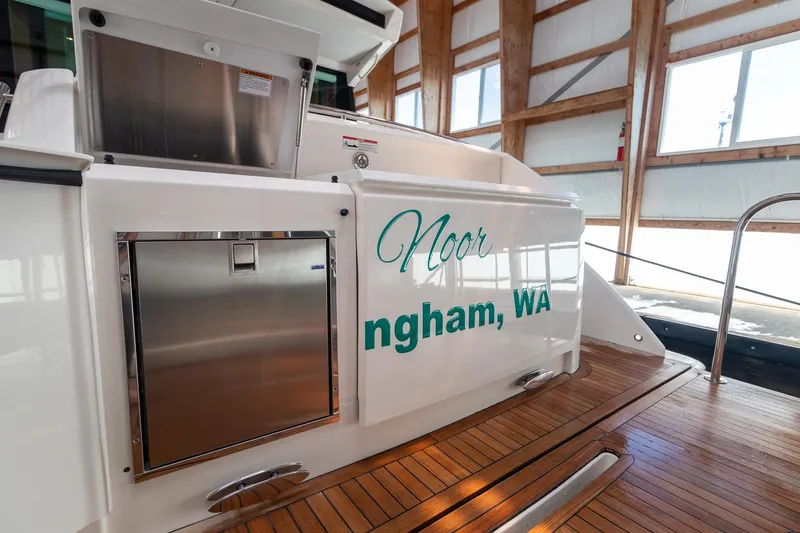 Slide: The Image of 2023 Tiara Yachts C44 Coupe docked, featuring teak deck and stainless steel details. - 8