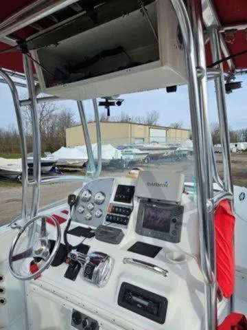 Slide: The Image of 2005 Baja 250 Sportfish Center Console with navigation equipment and steering wheel, docked outdoors. - 35