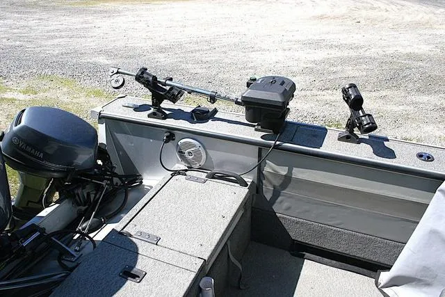 Slide: The Image of 2012 Alumacraft Trophy 205 Sport boat interior with fishing rod holders and Yamaha motor. - 12