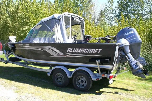 Slide: The Image of 2012 Alumacraft Trophy 205 Sport boat with Yamaha motor on trailer, parked outdoors. - 3