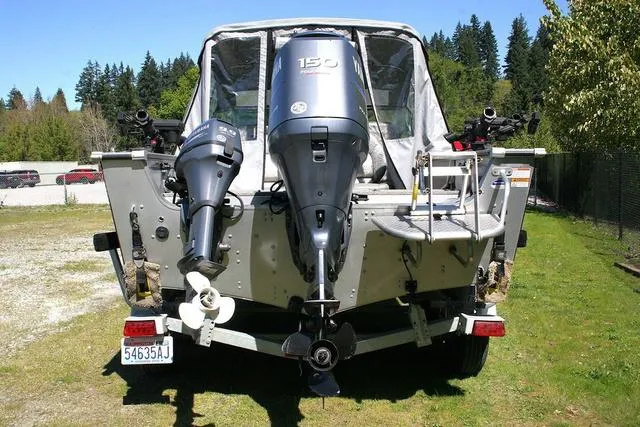 Slide: The Image of 2012 Alumacraft Trophy 205 Sport boat with dual outboard motors, parked on grass. - 4