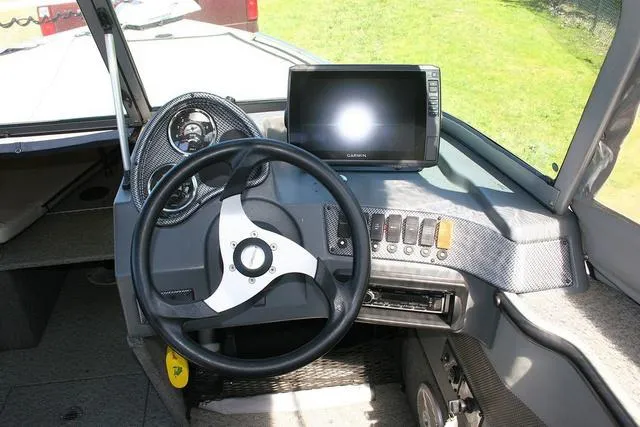Slide: The Image of 2012 Alumacraft Trophy 205 Sport dashboard with steering wheel and Garmin display. - 8