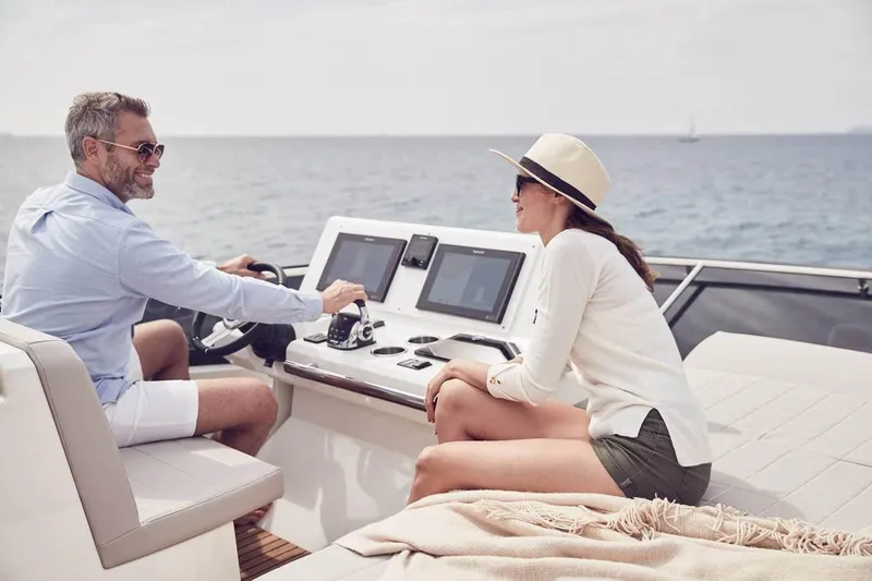 Slide: The Image of Couple enjoying a ride on a 2024 Prestige 520 Fly yacht, ocean in the background. - 14