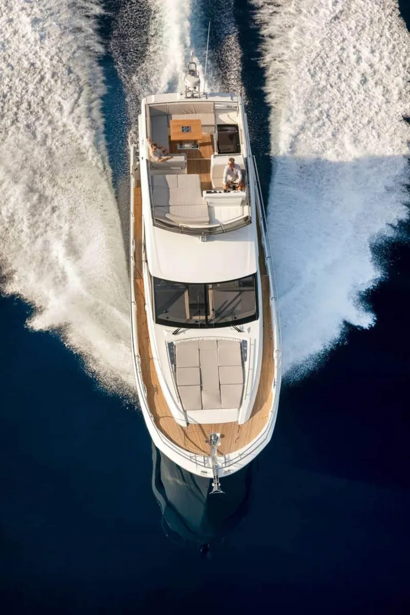Slide: The Image of 2024 Prestige 520 Fly yacht cruising on open water, aerial view. - 6