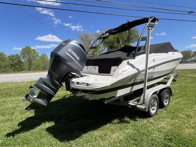 Slide: The Image of 2020 Regal 21 OBX boat on trailer, parked on grass near a building. - 17