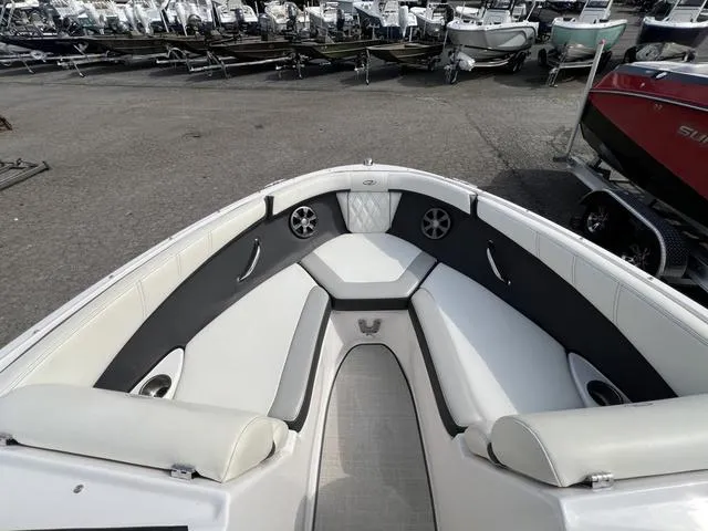 Slide: The Image of 2020 Regal 21 OBX boat interior with white and gray seating, parked in a marina. - 24