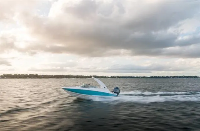 Slide: The Image of 2020 Regal 21 OBX boat cruising on a calm lake under a cloudy sky. - 4