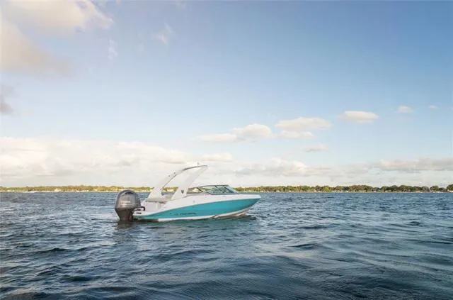 Slide: The Image of 2020 Regal 21 OBX boat cruising on open water under cloudy skies. - 5