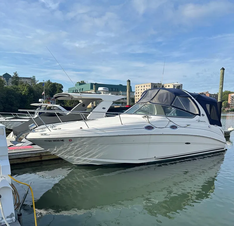 Slide: The Image of 2006 Sea Ray 280 Sundancer boat docked in a marina under a clear sky. - 0