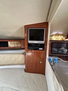 Slide: The Image of 2006 Sea Ray 280 Sundancer cabin interior with TV and kitchenette. - 22