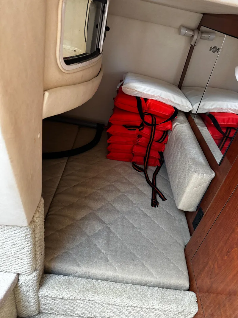 Slide: The Image of Interior cabin of 2006 Sea Ray 280 Sundancer with life jackets stacked neatly. - 24