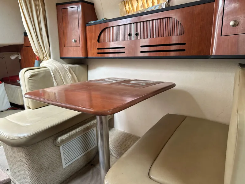 Slide: The Image of Interior of 2006 Sea Ray 280 Sundancer with wooden table and beige seating. - 25