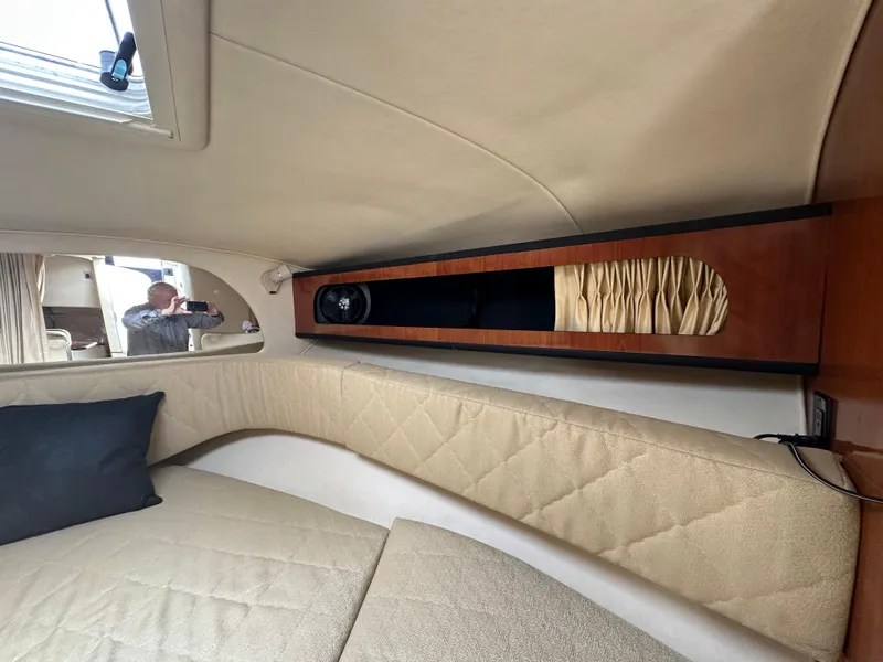 Slide: The Image of Interior cabin of 2006 Sea Ray 280 Sundancer with beige upholstery and wooden storage. - 30