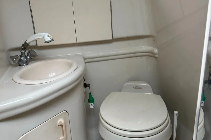 Slide: The Image of Compact bathroom in a 2006 Sea Ray 280 Sundancer boat, featuring a sink and toilet. - 31