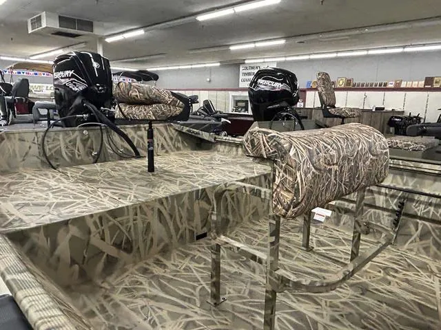 Slide: The Image of 2025 Lowe RX1870 Pathfinder boat with camouflage design in showroom. - 5