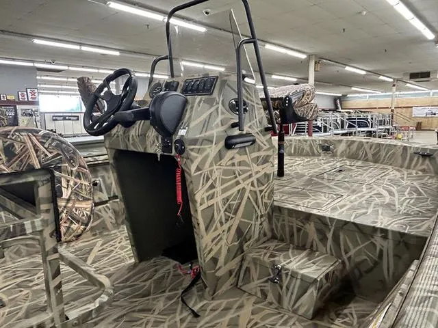 Slide: The Image of 2025 Lowe RX1870 Pathfinder boat with camouflage design in a showroom. - 7