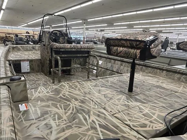 Slide: The Image of 2025 Lowe RX1870 Pathfinder boat with camouflage interior in a showroom. - 8