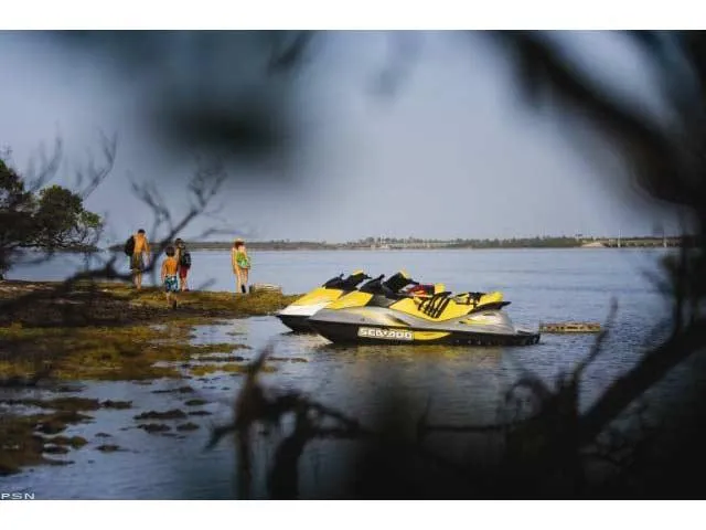 Slide: The Image of 2007 Sea-Doo GTI™ SE 155 jet skis on a serene lake with people nearby. - 16