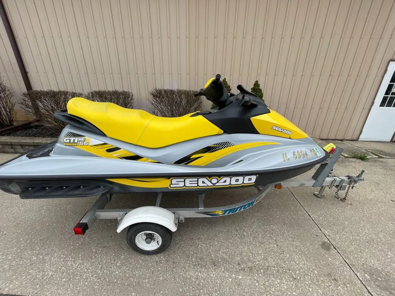 Slide: The Image of 2007 Sea-Doo GTI SE 155 jet ski on trailer, yellow and gray design. - 2