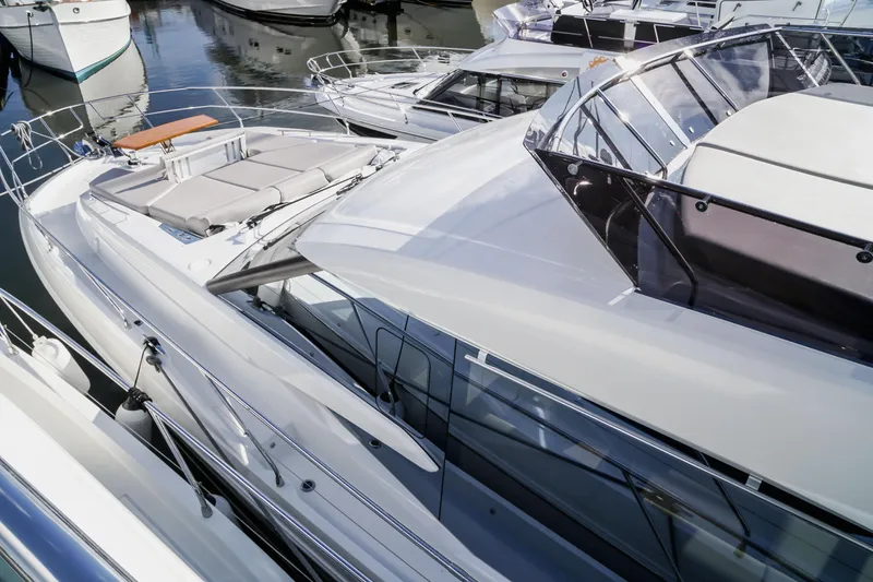 Slide: The Image of Luxury yacht Prestige 590, 2025 model, docked among other boats in a marina. - 20