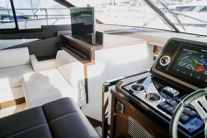 Slide: The Image of Luxurious interior of 2025 Prestige 590 yacht with modern dashboard and seating. - 10