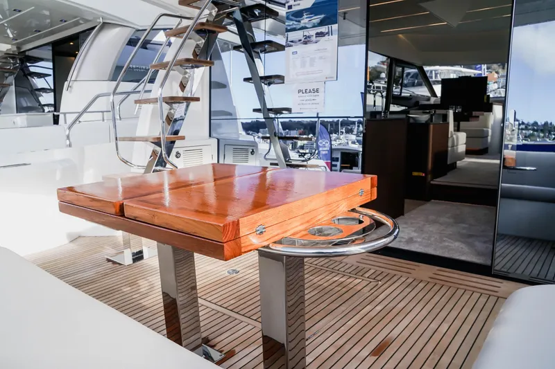 Slide: The Image of Luxurious Prestige 590 yacht interior with wooden table and modern staircase, 2025 model. - 16