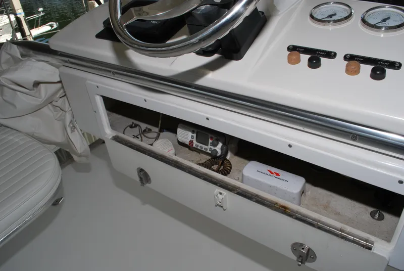 Slide: The Image of 2005 Stamas 370 Express boat dashboard with open storage compartment and gauges. - 13